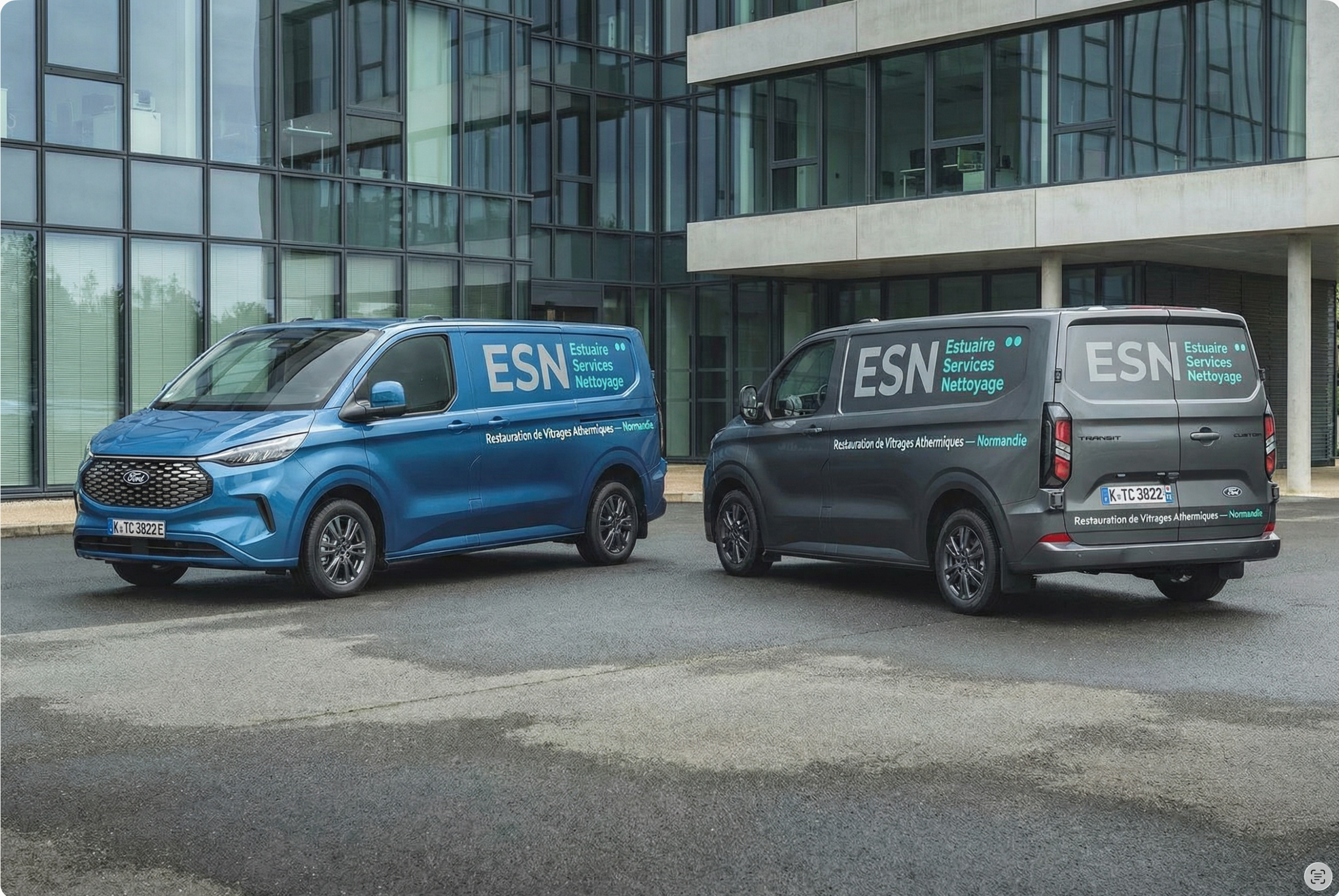 Deux camions ESN stationnés devant une façade vitrée